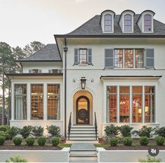 a large white house with many windows and steps leading up to the front door area