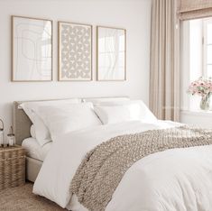 a bedroom with two paintings above the bed