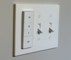 a white light switch sitting on top of a wall