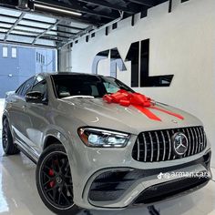 a mercedes car with a red bow on the hood