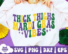 a woman wearing a white shirt that says thick thighs mardi gras vibes