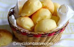 a basket filled with rolls on top of a table next to a white cloth napkin