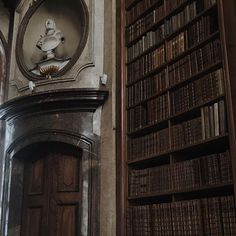 an old library with bookshelves and a clock on the wall above it's doorway