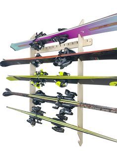 there are many skis and snowboards hanging on the rack in front of white background