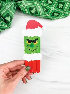 This popsicle stick Mr. Grinch craft is a fun activity for Christmas! Download the free printable template and make with the kids this December!