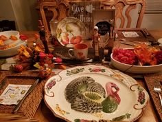 a thanksgiving table setting with turkey plates and silverware