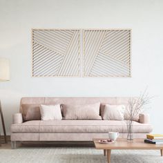 a living room with a couch, coffee table and two framed pictures on the wall