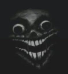 a creepy looking face with big eyes and fangs on it's head, in the dark