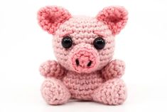 a pink crocheted teddy bear with big eyes