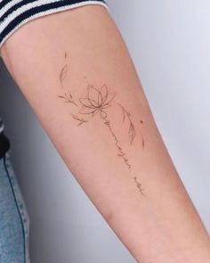 a woman's arm with a flower tattoo on it