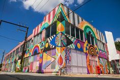 a multicolored building with lots of windows on the side and colorful artwork on the outside