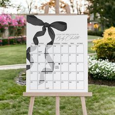 an easel with a calendar on it in the grass