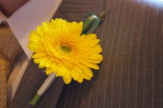 a yellow flower is placed on the lapel of a man's suit jacket