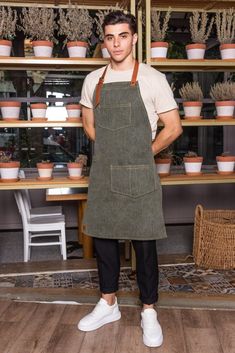 "Apron: 132BBF - Baxter Green * Chic and durable green denim apron, with neck strap, pockets and special tool or towel holder. Stylish, modern and comfortable all-day wear. * Available sizes: S/M: 70 x 55 cm (27.5\" x 21.5\") L/XL: 85 x 65 cm (33.5\" x 25.5\") * Pocket: Two pockets, center one at chest area and a larger one at left side of waist area. Both of them are perfect for your notebooks, PDAs, pens and bartending or other small tools. * Straps: Strong adjustable genuine Italian cow leather neck strap in light brown color, featuring metal bronze details for customizing the fit and buttons on both ends, for easy removal before washing. Straps on each side of the apron that can be tied around the waist. * Usage: Exclusively and thoughtfully designed for professionals such as baristas, Custom Apron, Type Logo, Denim Apron, Apron Kitchen, Custom Aprons, Kitchen Apron, Pastry Chef, Kitchen Aprons, Linen Apron