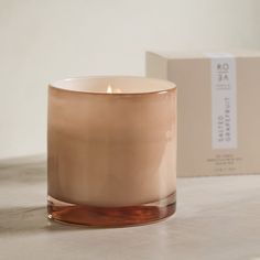 a candle sitting on top of a table next to a box with an object in the background