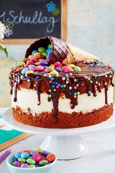 a cake with chocolate frosting and sprinkles sitting on top of a table