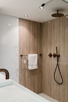 a bathroom with a sink, shower head and towel hanging on the wall next to it