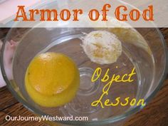 an orange in a glass bowl with the words armor of god on it next to a lemon