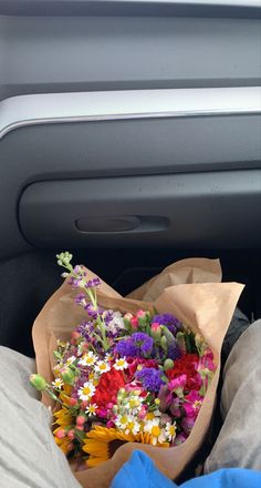 a bunch of flowers sitting in the back seat of a car