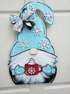 a door hanger decorated with an image of a gnome holding a coffee mug and snowflakes