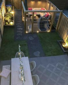 an aerial view of a backyard with lights on the deck and patio furniture in the background