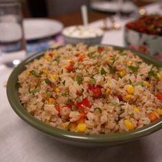 a bowl filled with rice and veggies on top of a white table cloth