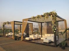 an outdoor wedding setup with white couches and flowers