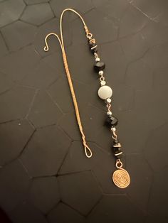 a long necklace with black and white beads hanging from it's side on a table