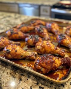 some chicken wings are sitting in a pan on the counter top, ready to be cooked