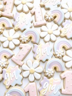 decorated cookies with the number one and flowers in pastel pink, white, and yellow