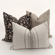 three decorative pillows on a white background