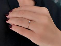 a woman's hand with a diamond ring on it