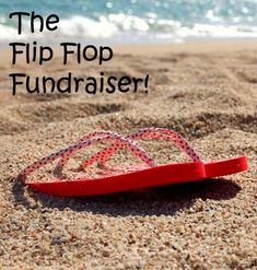 a pair of flip flops sitting on top of a sandy beach