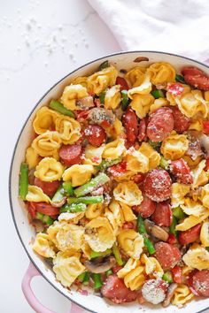 a pan filled with pasta and vegetables on top of a table