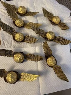 some gold chocolates with wings on them