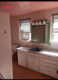 a bathroom with two windows and a sink