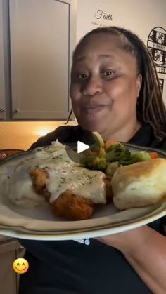 a woman holding a plate with some food on it