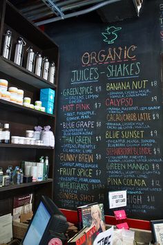 a blackboard with some writing on it in a store filled with bottles and other items