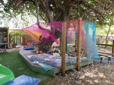 an outdoor play area with hammocks and toys