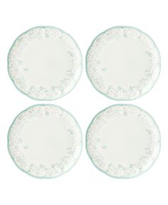 four white plates with lacy designs on them