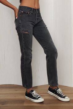 Classic fit, softened black Levi's 501 button fly jeans. Features distress and patches throughout. Perfect staple pair of jeans to be comfortable and effortlessly chic to invest in. 100% Cotton. Model is 5'7" and waist 26. Listed size 29.- Waist: 28" - Hips: 36" - Rise: 10.5" - Inseam: 30.5" - Leg Opening: 8" Black Distressed Rigid Denim Bottoms, Black Distressed Rigid Denim Jeans, Black Distressed Jeans In Rigid Denim, Edgy Black Rigid Denim Jeans, Levi's Distressed Bottoms For Fall, Levi's Ripped Straight Leg Jeans, Trendy Ripped Levi's Jeans, Levi's Straight Leg Washed Black Jeans, Levi's Black Straight Leg Jeans