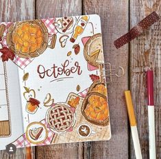 an open notebook with the words october written on it next to pencils and markers