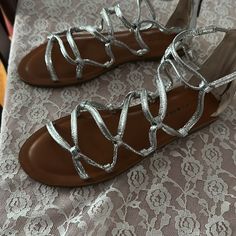 Silver Metallic Flat Gladiator Sandal Never Worn Spring Silver Strappy Sandals, Silver T-strap Sandals For Spring, Metallic Gladiator Sandals, Comfortable Wedges Sandals, Bronze Sandals, Lucky Brand Sandals, Gladiator Flats, Black Open Toe Heels, Studded Gladiator Sandals