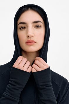 Enjoy maximum coverage in our Elba Sweatshirt Dress. Fashioned from our midweight, breathable European French Terry, she'll hug you all day in her full-body silhouette featuring an ankle-grazing hem and side vents. Zipped front pockets make space for essentials. And seamlessly attached to the hood is a gaitor mask you can raise up to the nose for added protection and insulation. | Emily, in black, is 5'9.5" (177 cm) tall, wearing size XS. Sam, in black and in olive, is 5'8" (173 cm) tall, wearing size XS. Total length approximately 55" (140 cm).Midweight European French Terry (95% Cotton; 4% Elastane).Machine wash cold or dry clean. Do not tumble dry. Do not bleach. Iron on low heat. Designed in NYC. Handcrafted in Europe. | Marcella Elba Long Sleeve Sweatshirt Dress in Black | Women's Siz Black Tops For Daywear In Winter, Black Midweight Athleisure Tops, Black Go-dry Tops For Winter, Black Functional Tops With Ribbed Cuffs, Functional Black Tops With Ribbed Cuffs, Black Midweight Long Sleeve Hoodie, Long Sleeve Sweatshirt Dress, Body Silhouette, Long Sleeve Sweatshirt