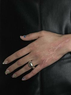 a woman's hand with lightning painted on it and two rings around her wrist