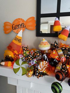 an assortment of candy and decorations on a fireplace mantel in a halloween themed room