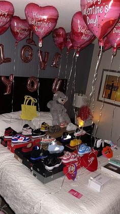 valentine's day balloons and shoes on a bed