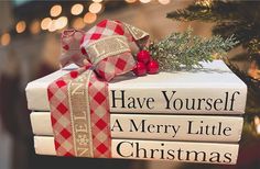 three books stacked on top of each other next to a christmas tree