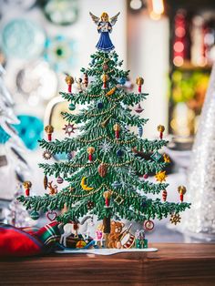 a small christmas tree sitting on top of a wooden table next to other holiday decorations