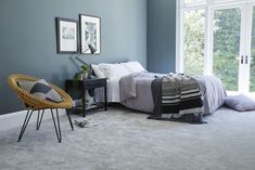 a bedroom with blue walls and white carpet